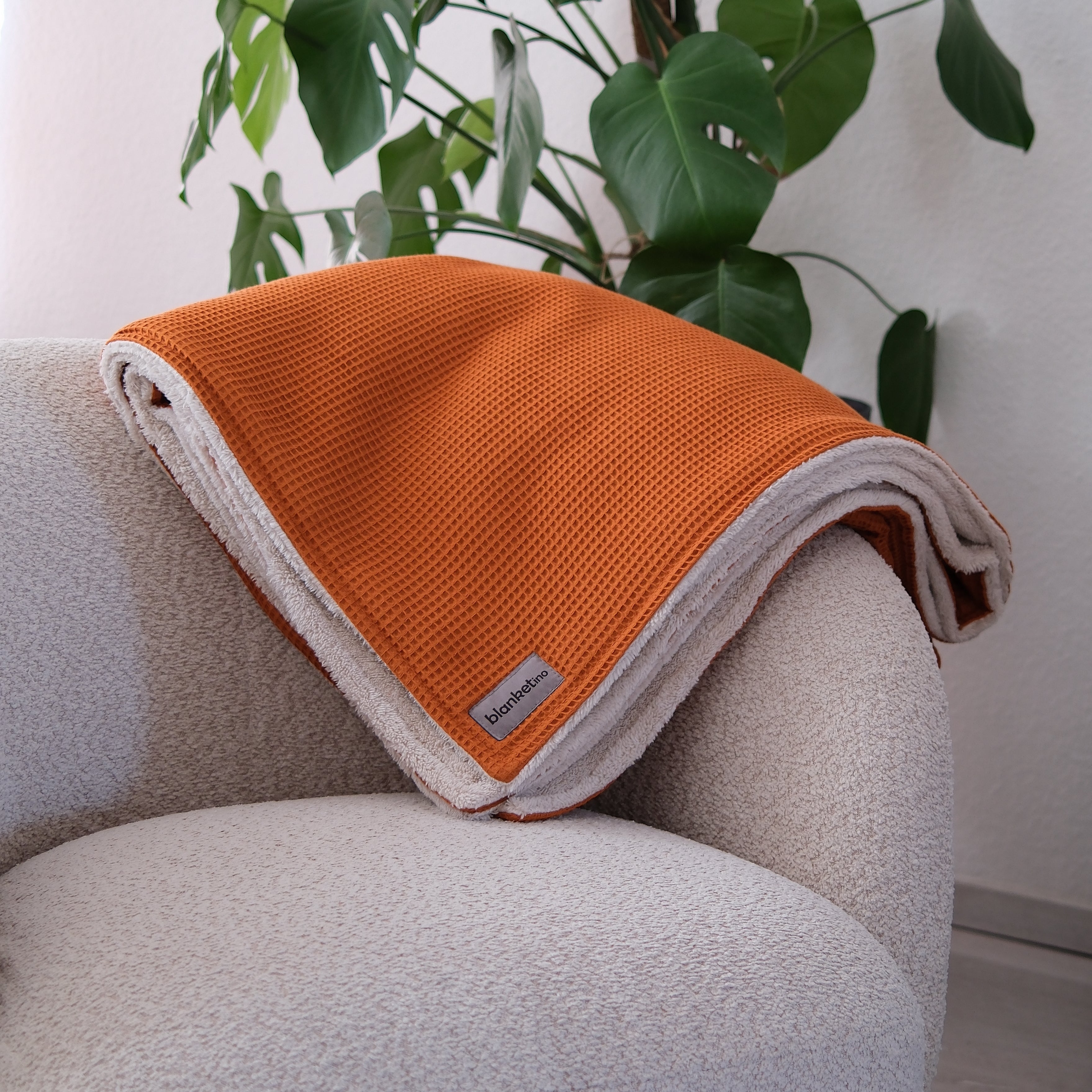 Kuscheldecke "Vollkommen" Cognac Beige – dekoriert auf einem Sofa