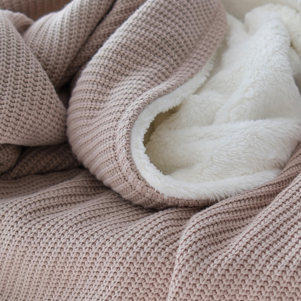Weiche Baumwollstrick-Kuscheldecke in Champagner mit flauschiger Innenseite von blanketino.de, ideal für gemütliche Abende.