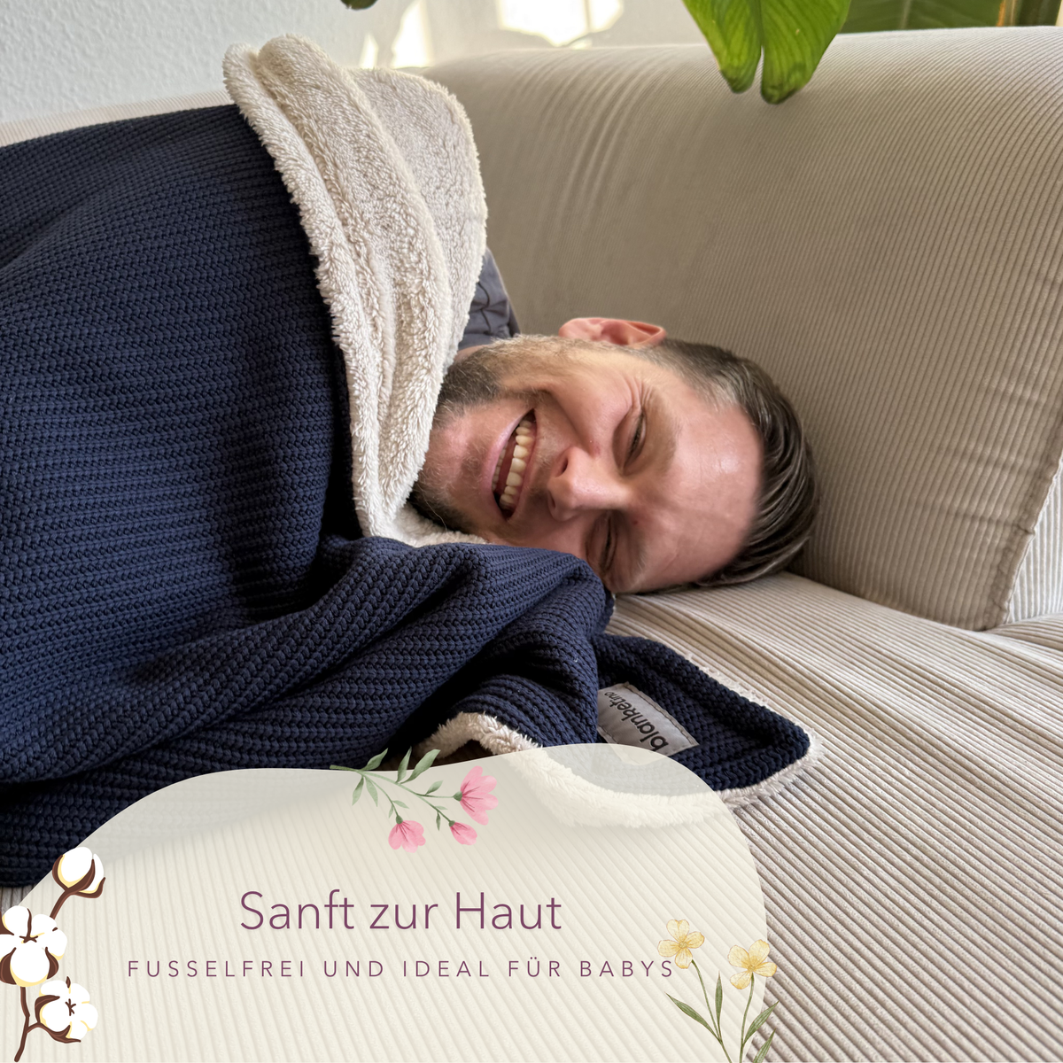 Kuscheldecke aus Baumwollstrick in Dunkelblau und Beige, weich und gemütlich auf einem Sofa, von blanketino.de