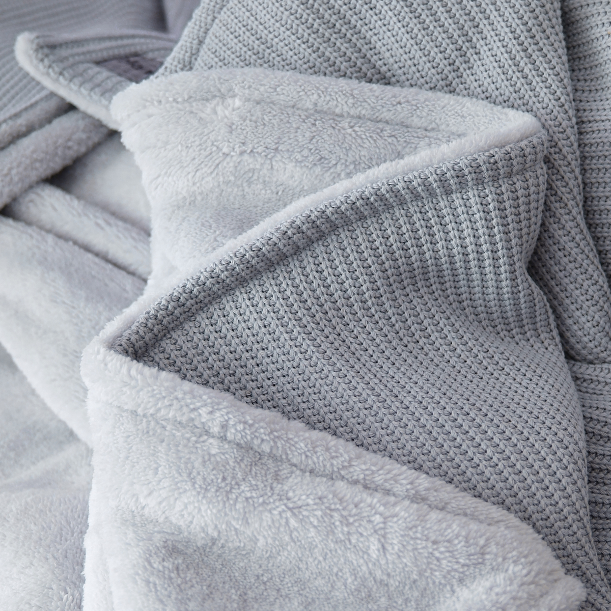 Hellegraue Baumwollstrick Kuscheldecke von blanketino.de, weiche, flauschige Wohndecke mit gemütlicher Innenseite.