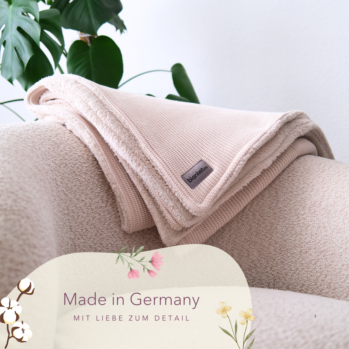 Weiche Baumwollstrick-Kuscheldecke in Creme von blanketino.de auf einem Sessel, handgefertigt in Deutschland.