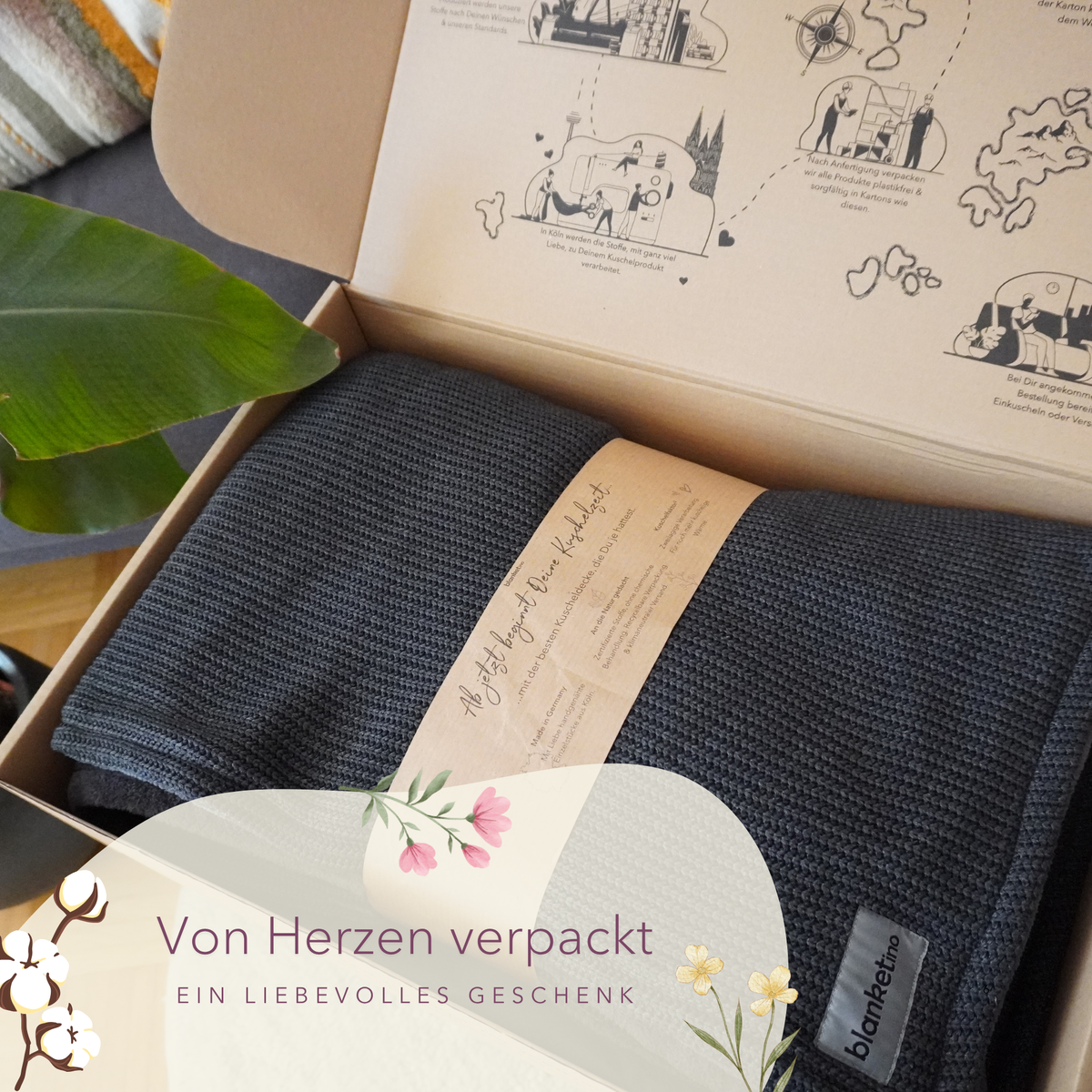Dunkelgraue Kuscheldecke aus Baumwollstrick von blanketino.de in Geschenkverpackung, ideal für gemütliche Stunden zu Hause