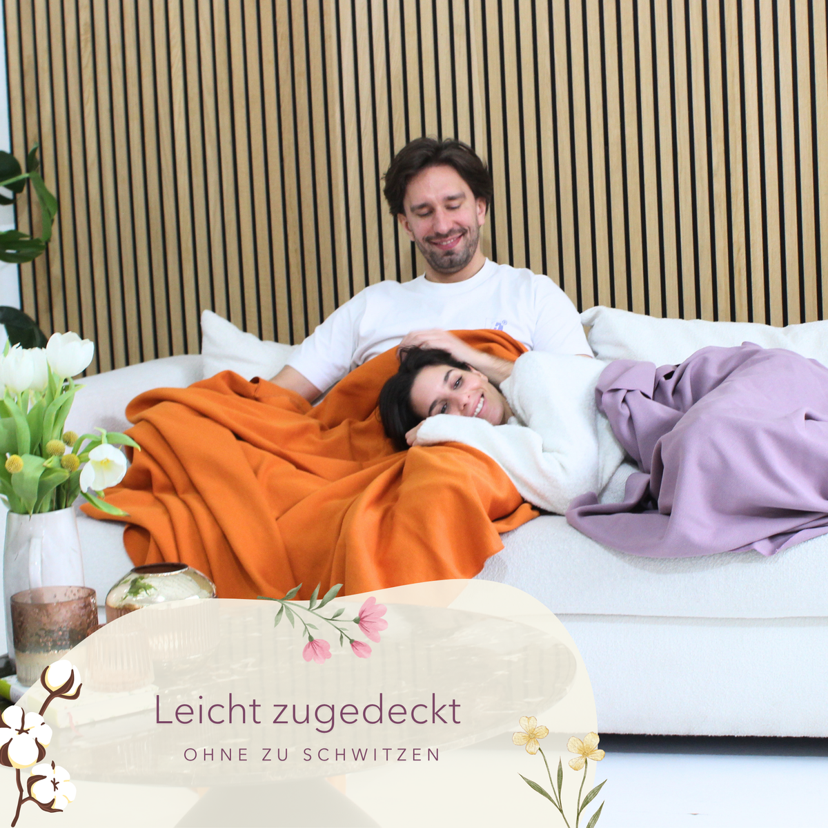 Leichte Baumwolldecke in Orange, Sommerdecke von blanketino.de, liegt kuschelig auf einem Sofa.