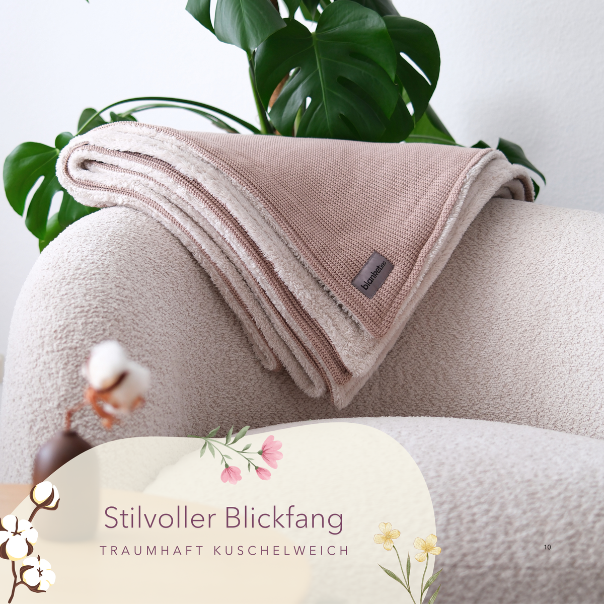 Kuscheldecke mit Baumwollstrick in Mandel-Beige, gefaltet auf einem Sessel, weich und bequem für gemütliche Stunden.