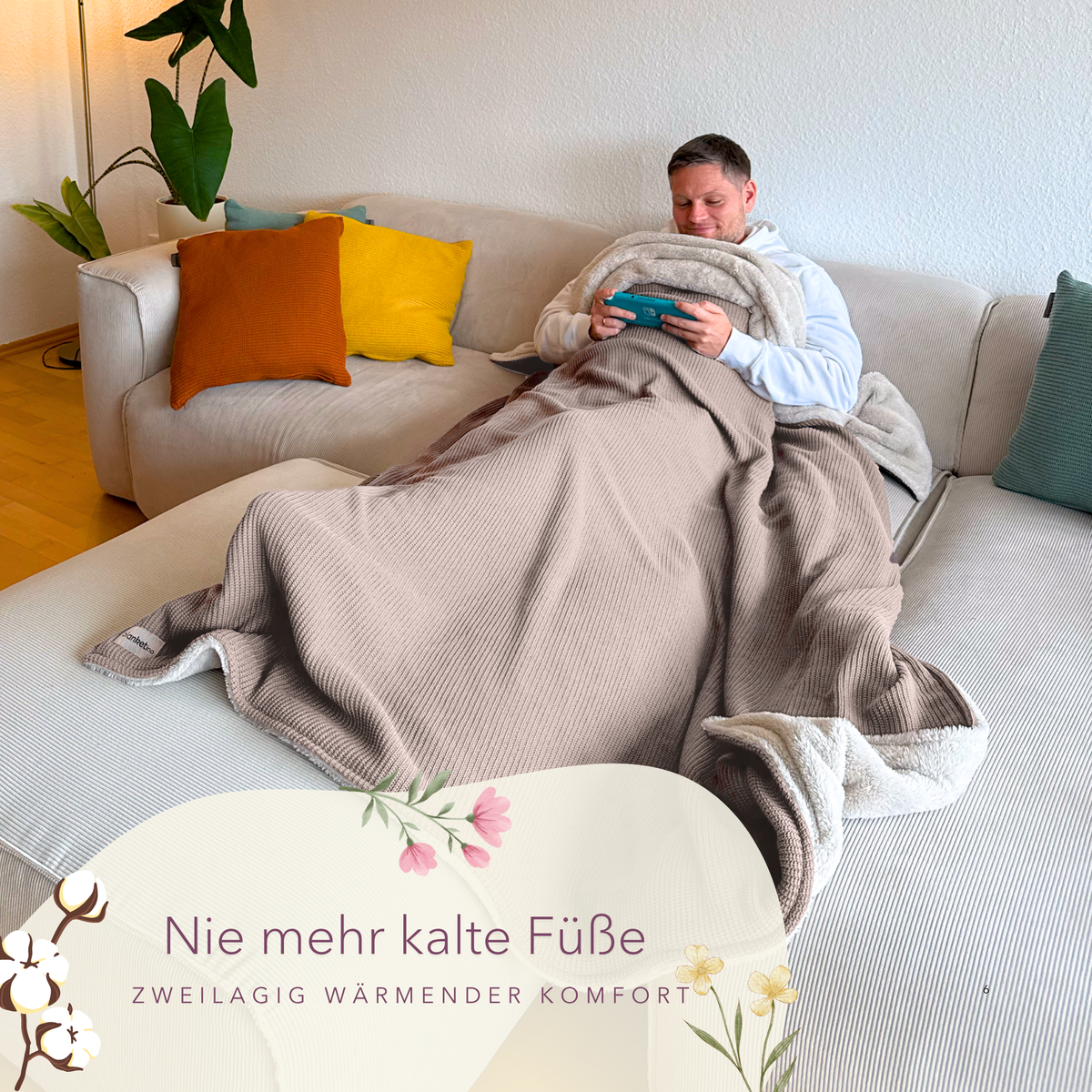 Weiche Baumwollstrick-Kuscheldecke in Mandel-Beige, perfekt zum Einkuscheln, mit einer Person und Tasse, warme Füße.