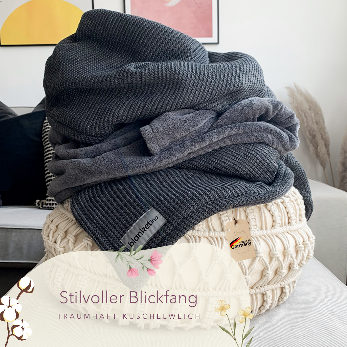 Dunkelgraue Kuscheldecke mit Baumwollstrick von blanketino.de, dekorativ auf einem Kissen liegend.