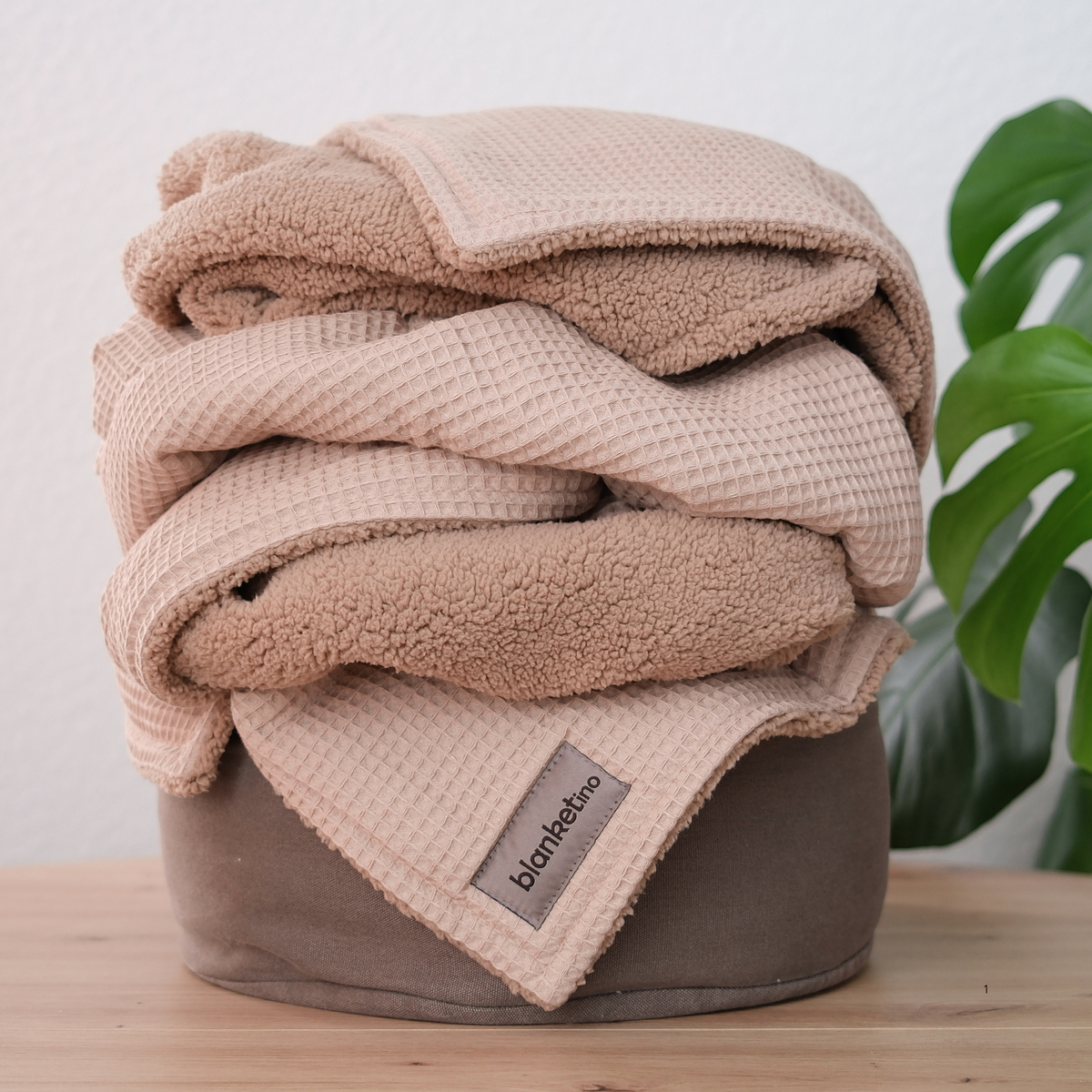 Beige Kuscheldecke mit Teddy-Fleece von blanketino.de, gefaltet, samtig weich und waffelpique für gemütliche Stunden.