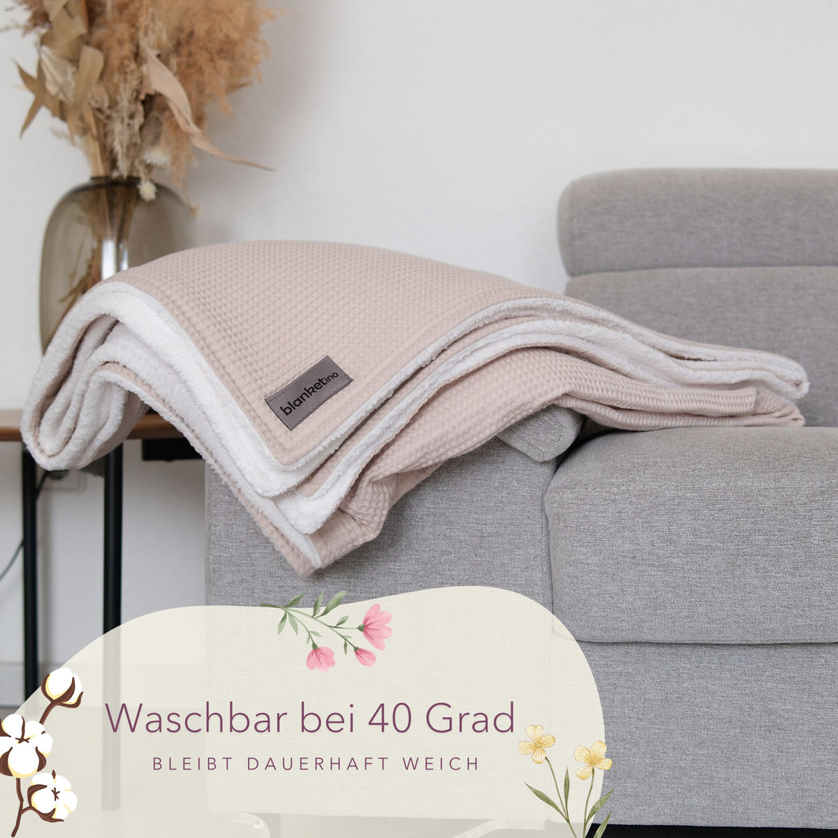 Weiche Kuscheldecke "Vollkommen" von blanketino.de in Creme mit Waffelpique, gefaltet auf Sofa, waschbar und angenehm warm.