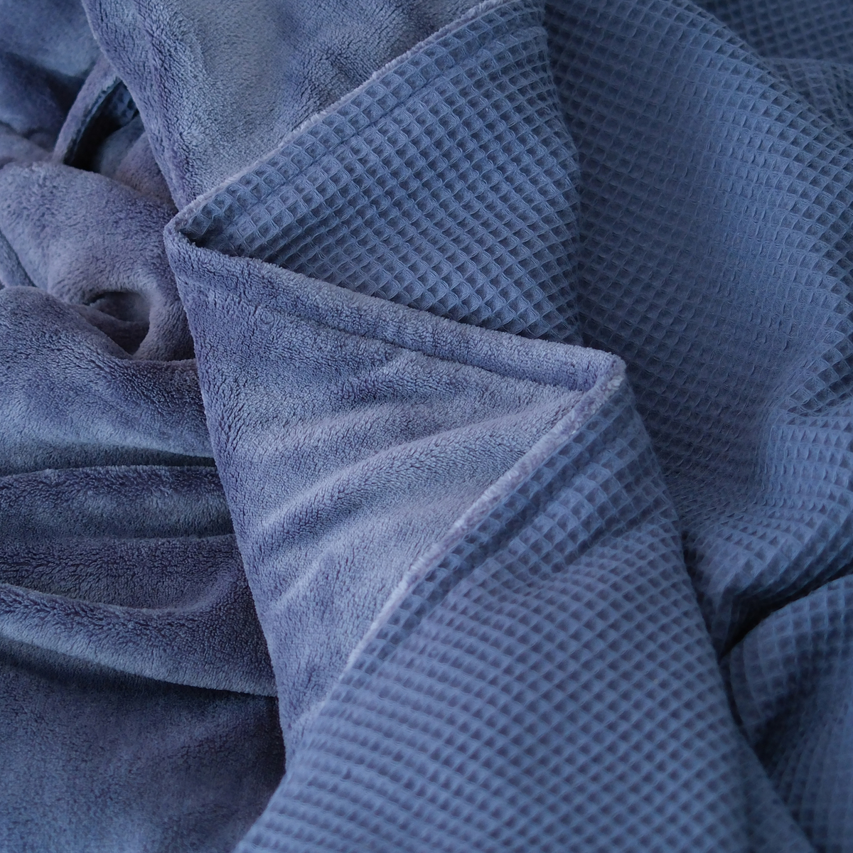 Dunkelblaue Kuscheldecke "Vollkommen" von blanketino.de mit Waffelpique-Design und weichem Kuschelstoff im Nahaufnahmebild