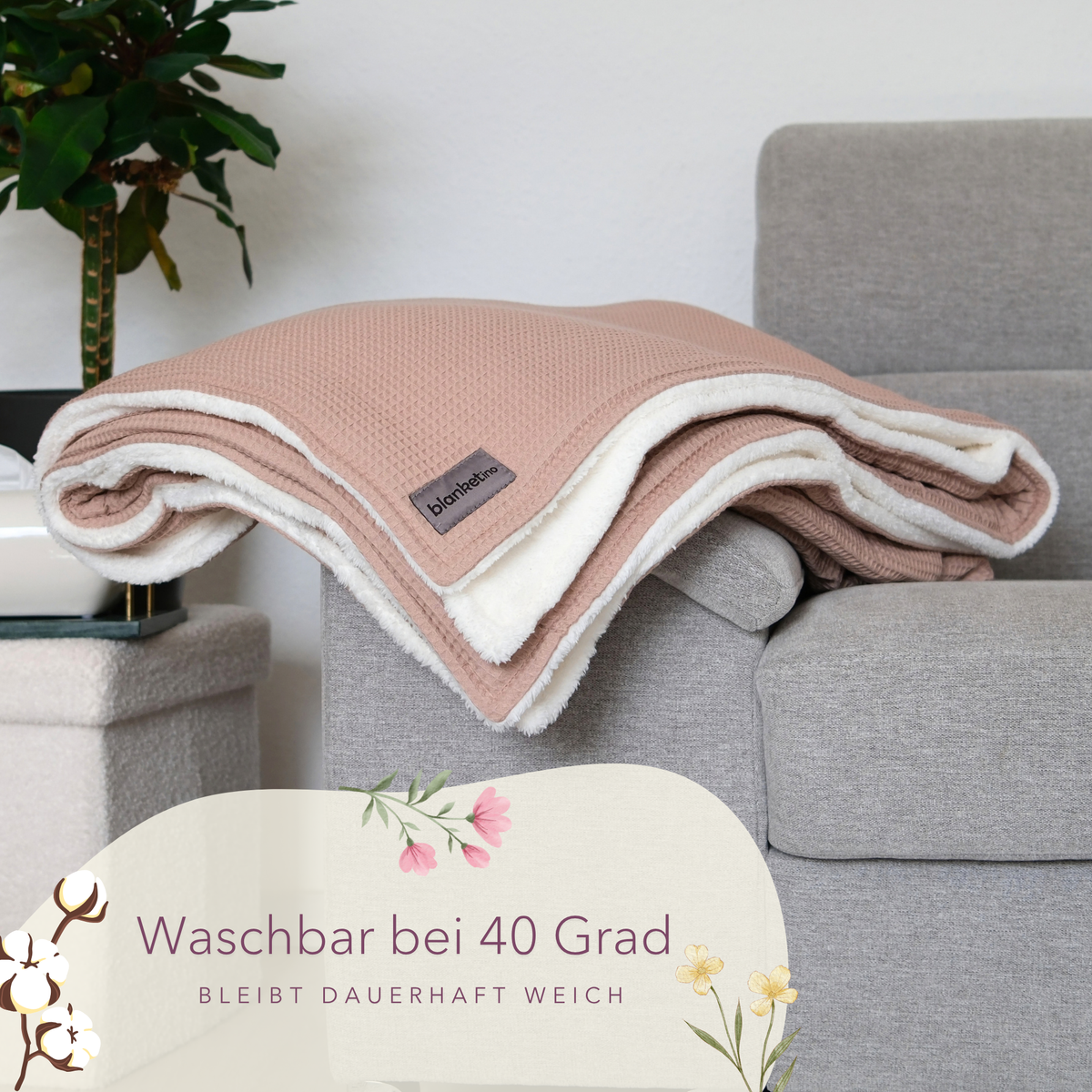 Gefaltete Kuscheldecke "Vollkommen" Latte Macchiato von blanketino.de auf Sofa mit Waffelpique-Textur.