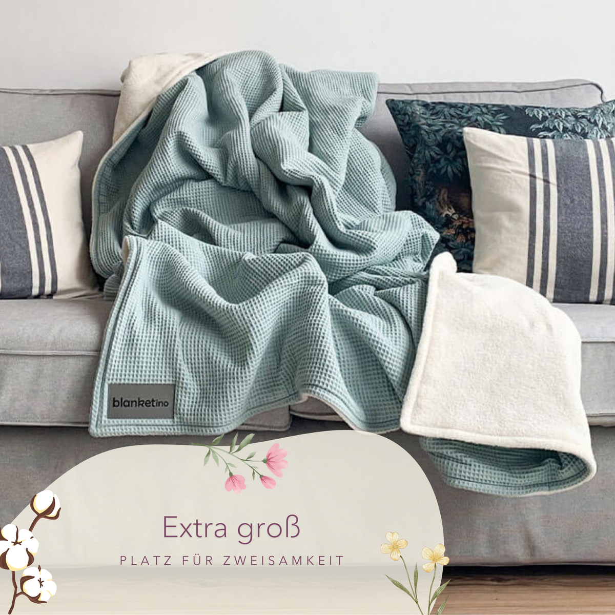 Weiche Mint-Kuscheldecke "Vollkommen" aus Waffelpique von blanketino.de auf einem Sofa drapiert