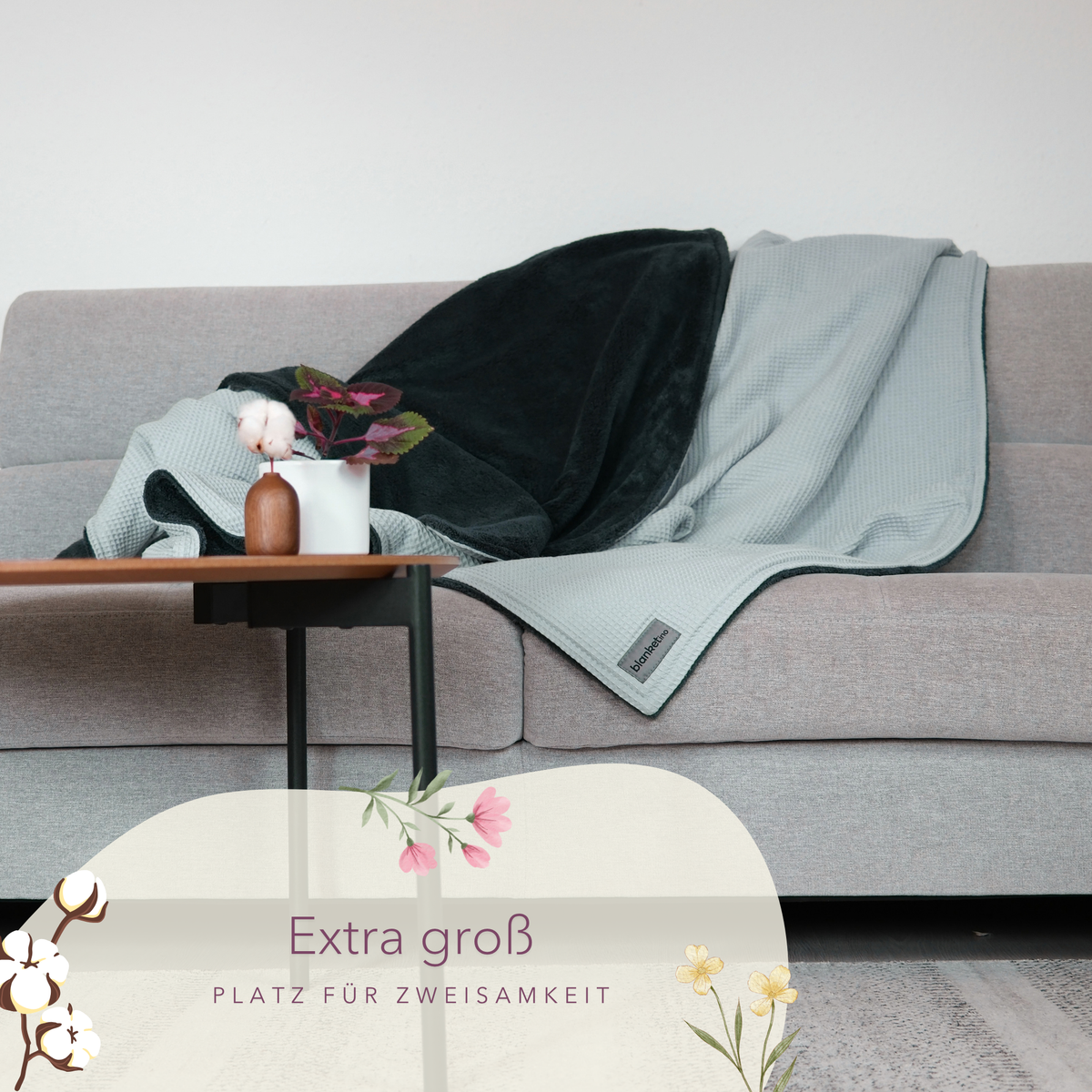 Weiche Kuscheldecke "Vollkommen" in Mint und Smaragdgrün auf einem Sofa, aus Waffelpique von blanketino.de.